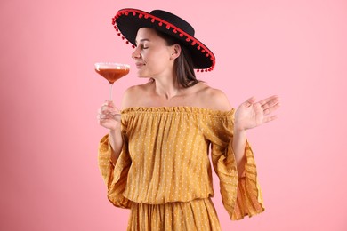 Photo of Beautiful woman in black Flamenco hat and dress on pink background