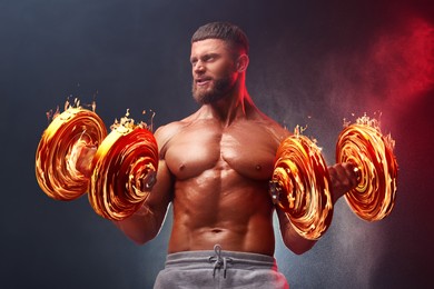 Image of Bodybuilder exercising with flaming dumbbells in smoke against dark background