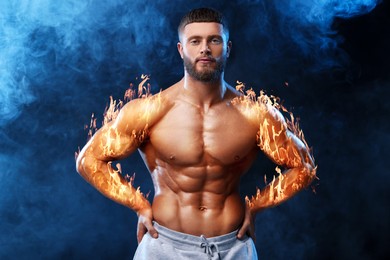 Image of Bodybuilder in smoke against black background. Muscular man with flaming arms