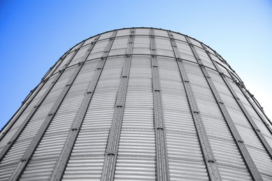 Image of Modern granary for storing cereal grains against blue sky, low angle view