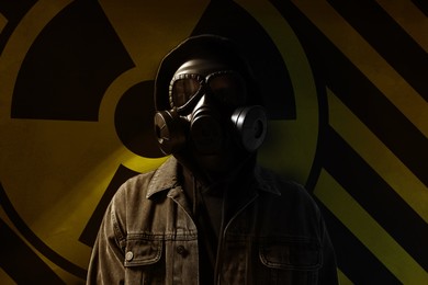 Image of Man wearing gas mask against radioactive sign