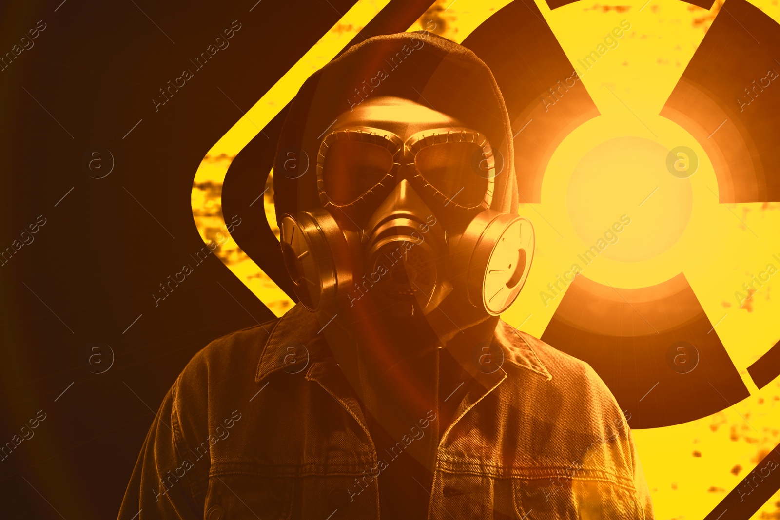 Man wearing gas mask black background. Glowing radioactive sign behind him Image of Man wearing gas mask black background. Glowing radioactive sign behind him