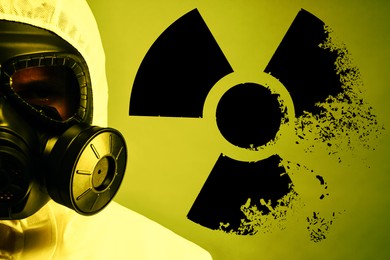 Image of Man wearing hazmat suit and gas mask on color background. Dissolving radioactive sign behind him
