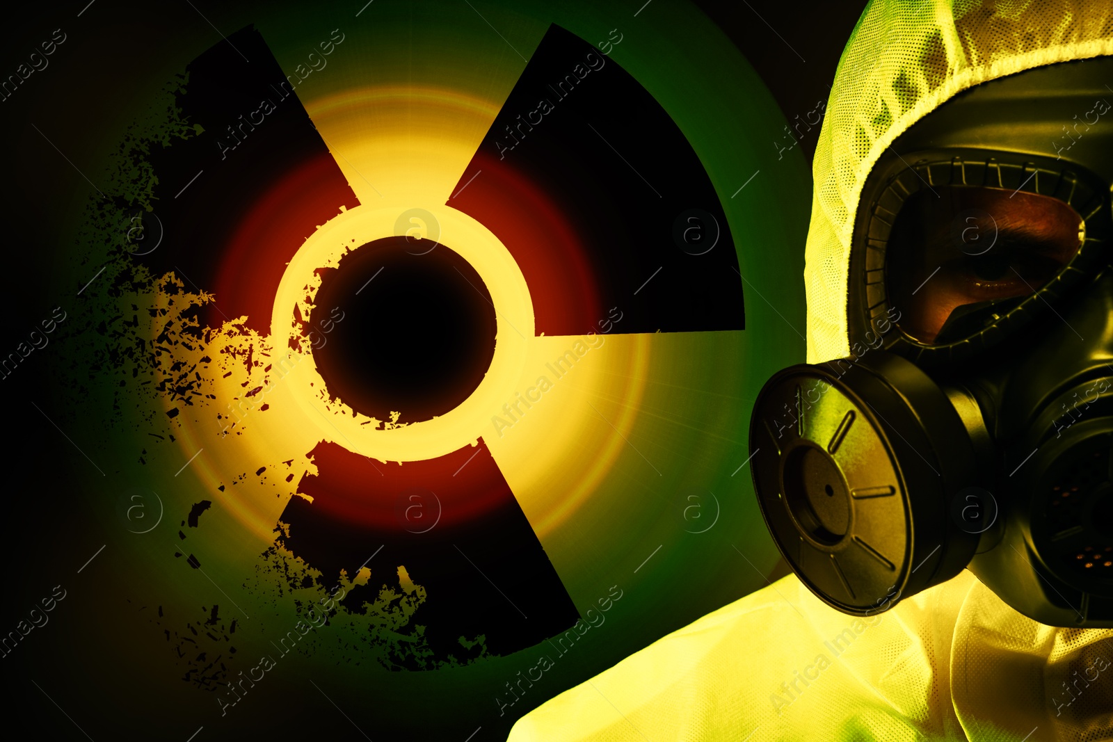 Image of Man wearing hazmat suit and gas mask on dark background. Glowing radioactive sign behind him