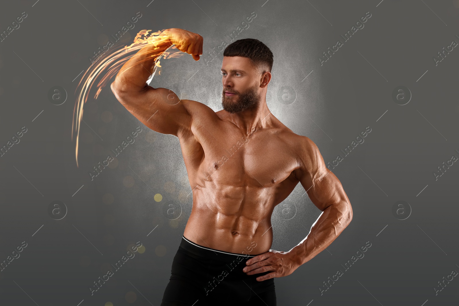Image of Bodybuilder showing his biceps against grey background. Muscular man with flaming hand