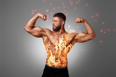 Image of Bodybuilder showing his biceps against grey background. Muscular man with flaming body