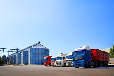 Image of Modern granaries for storing cereal grains and trucks outdoors