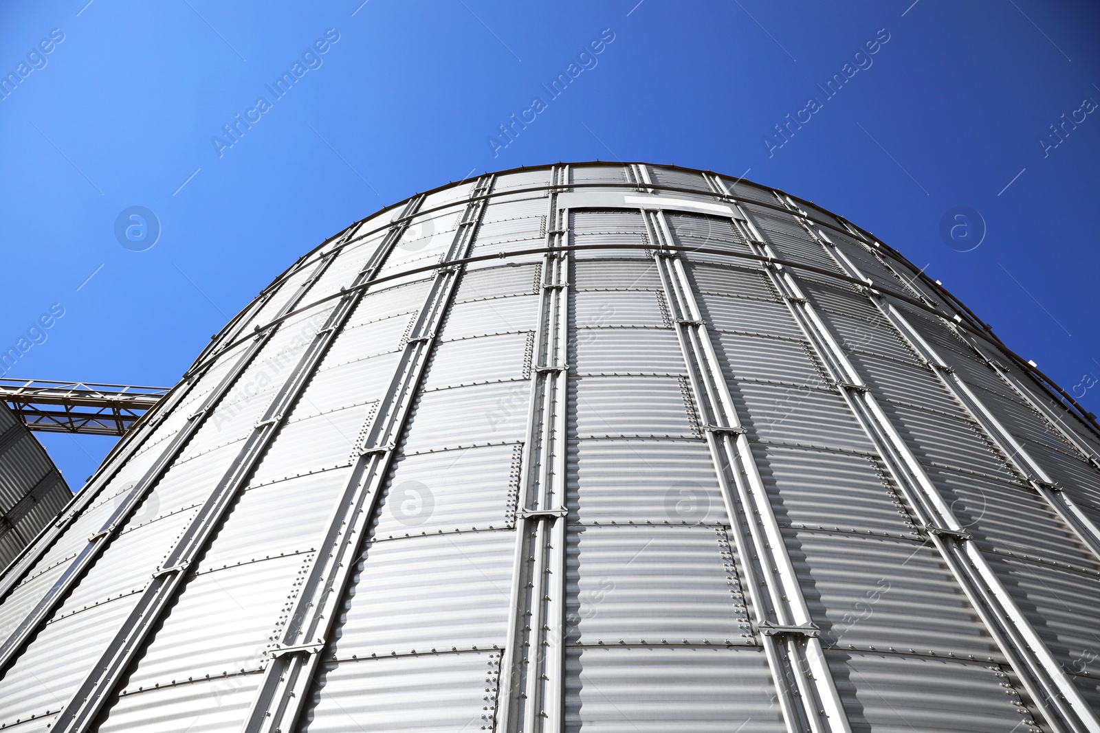 Image of Modern granary for storing cereal grains against blue sky, low angle view
