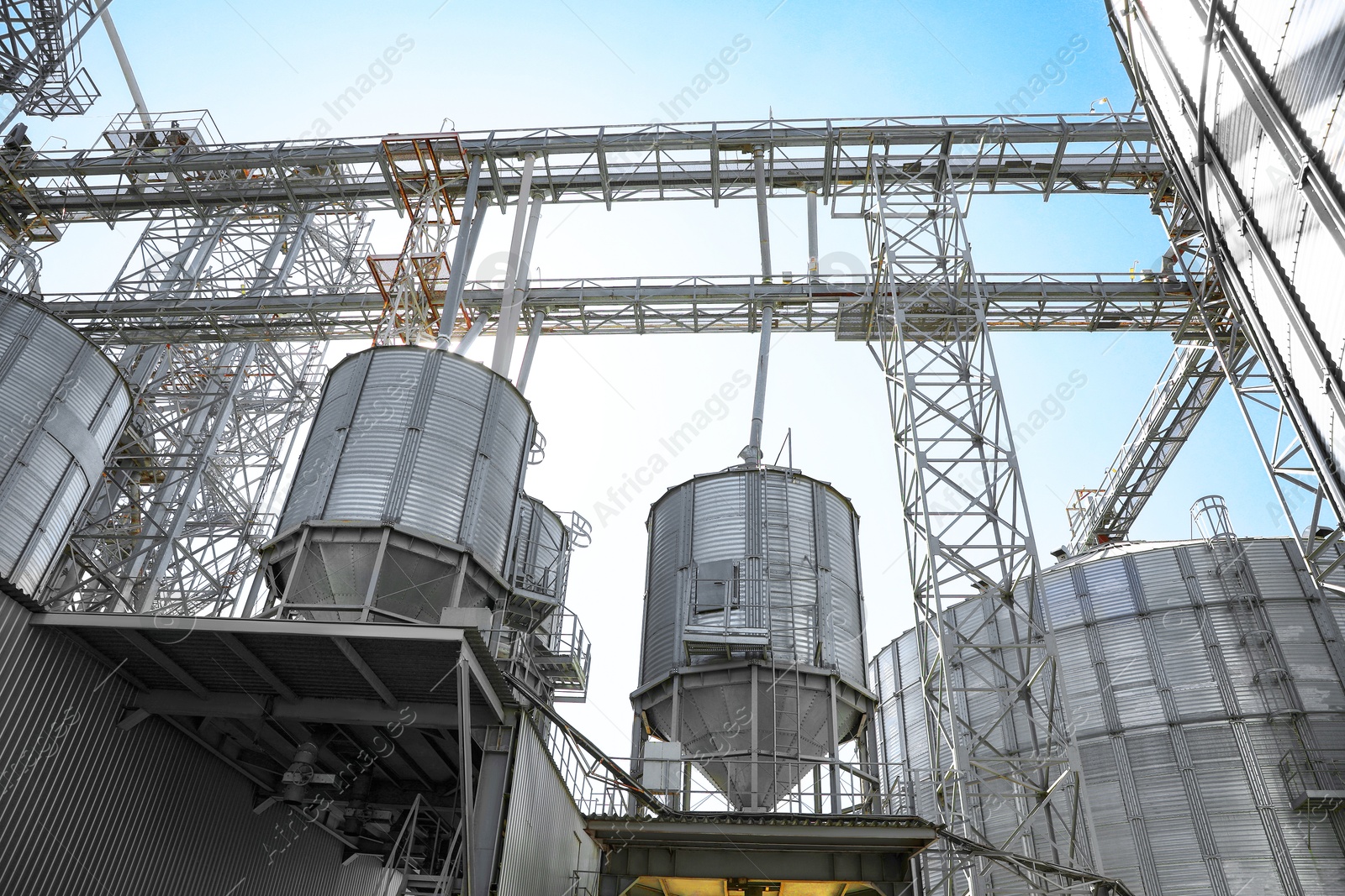 Modern granaries for storing cereal grains against blue sky, low angle view Image of Modern granaries for storing cereal grains against blue sky, low angle view
