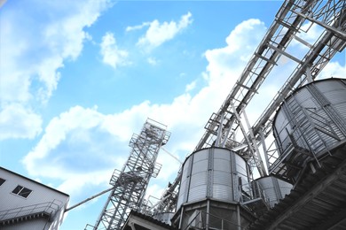 Image of Modern granaries for storing cereal grains against blue sky, low angle view