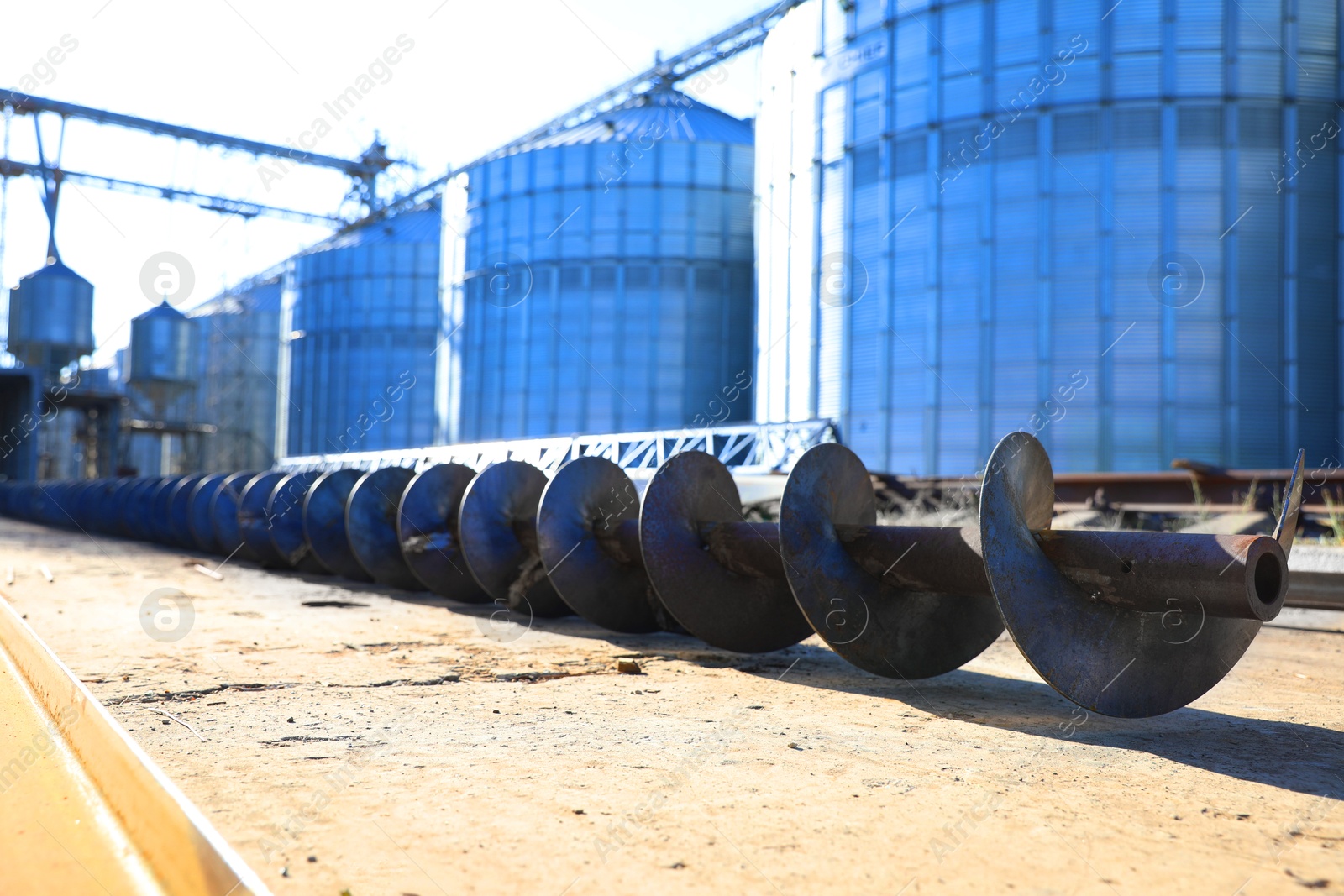 Steel screw for grain elevator conveyor on ground near granary, closeup Image of Steel screw for grain elevator conveyor on ground near granary, closeup