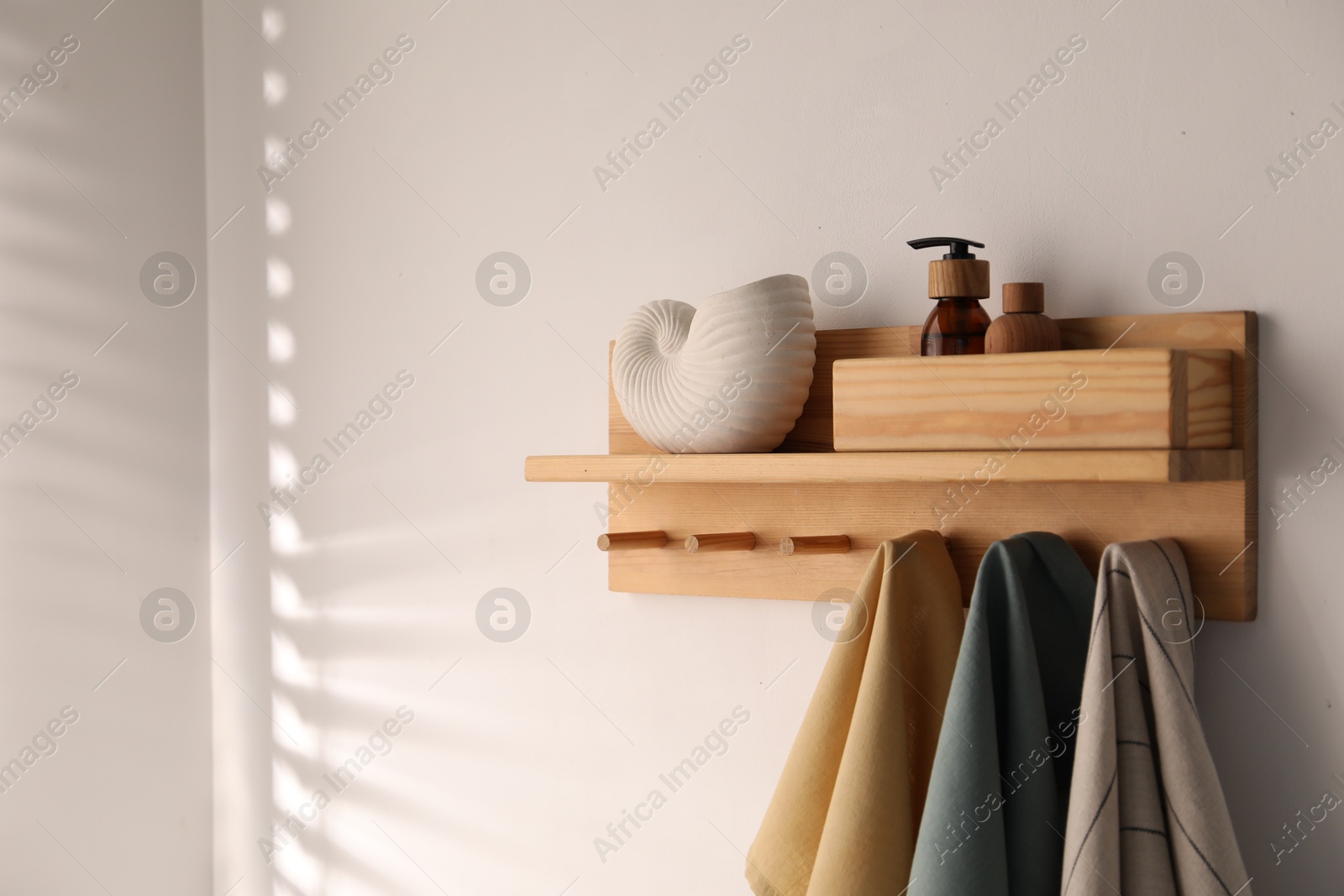 Shelf with cosmetic products and towels on white background. Space for text Photo of Shelf with cosmetic products and towels on white background. Space for text