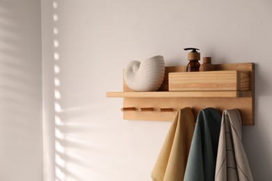 Photo of Shelf with cosmetic products and towels on white background. Space for text