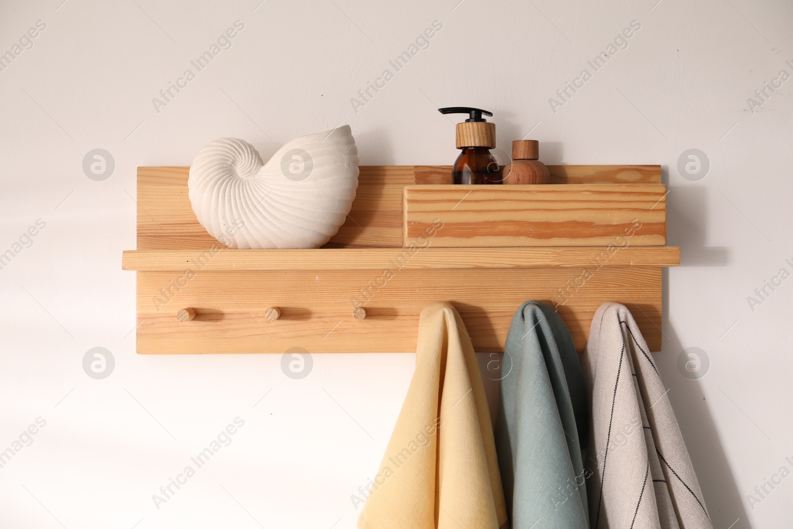 Shelf with cosmetic products and towels on white background Photo of Shelf with cosmetic products and towels on white background