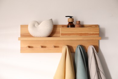 Photo of Shelf with cosmetic products and towels on white background