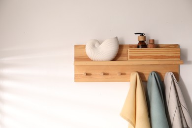 Photo of Shelf with cosmetic products and towels on white background