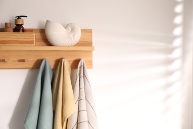 Photo of Shelf with cosmetic products and towels on white background. Space for text