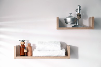 Photo of Wooden shelves with bathroom necessities on white background