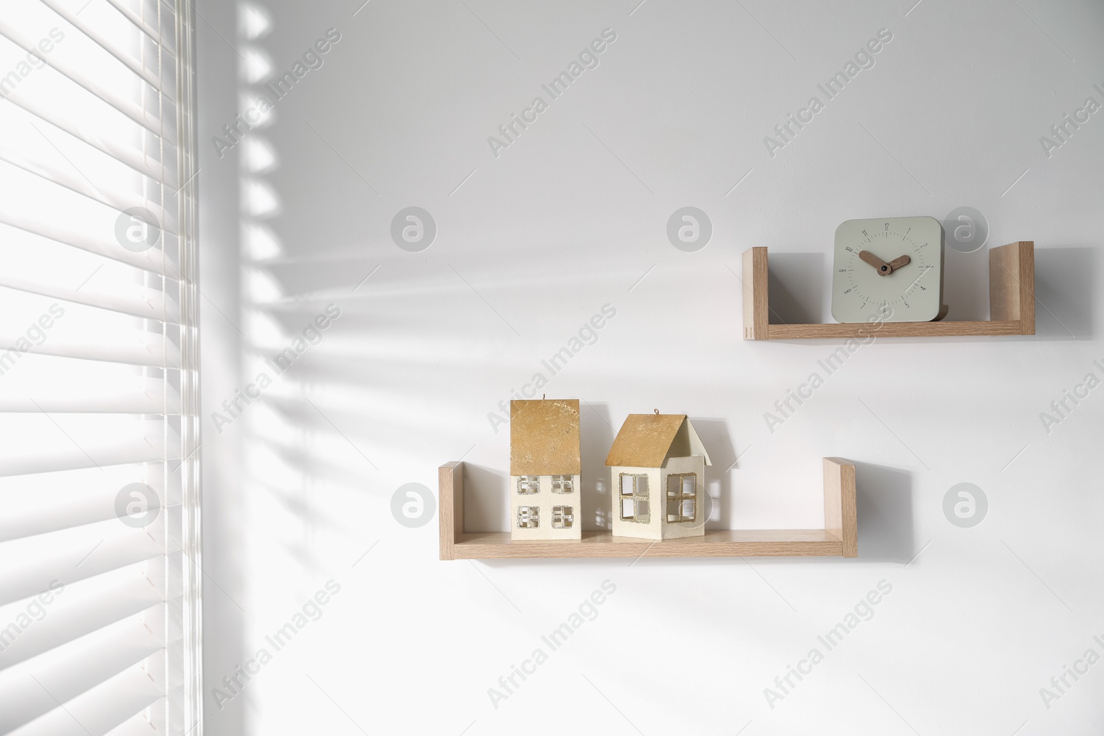 Wooden shelves with decor on white wall Photo of Wooden shelves with decor on white wall