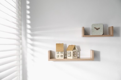Photo of Wooden shelves with decor on white wall