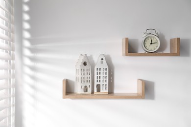 Photo of Wooden shelves with decor on white wall