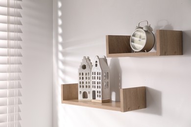 Photo of Wooden shelves with decor on white wall