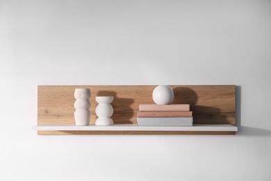Photo of Wooden shelf with books and decor on white background