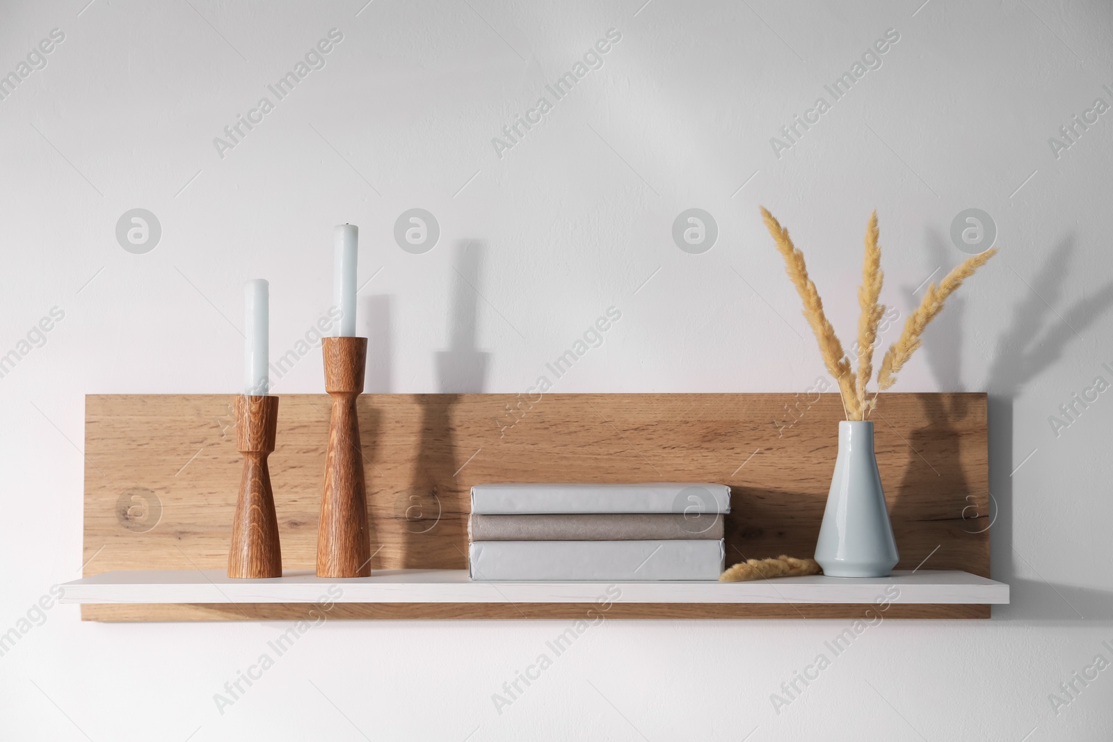 Photo of Wooden shelf with books and decor on white background