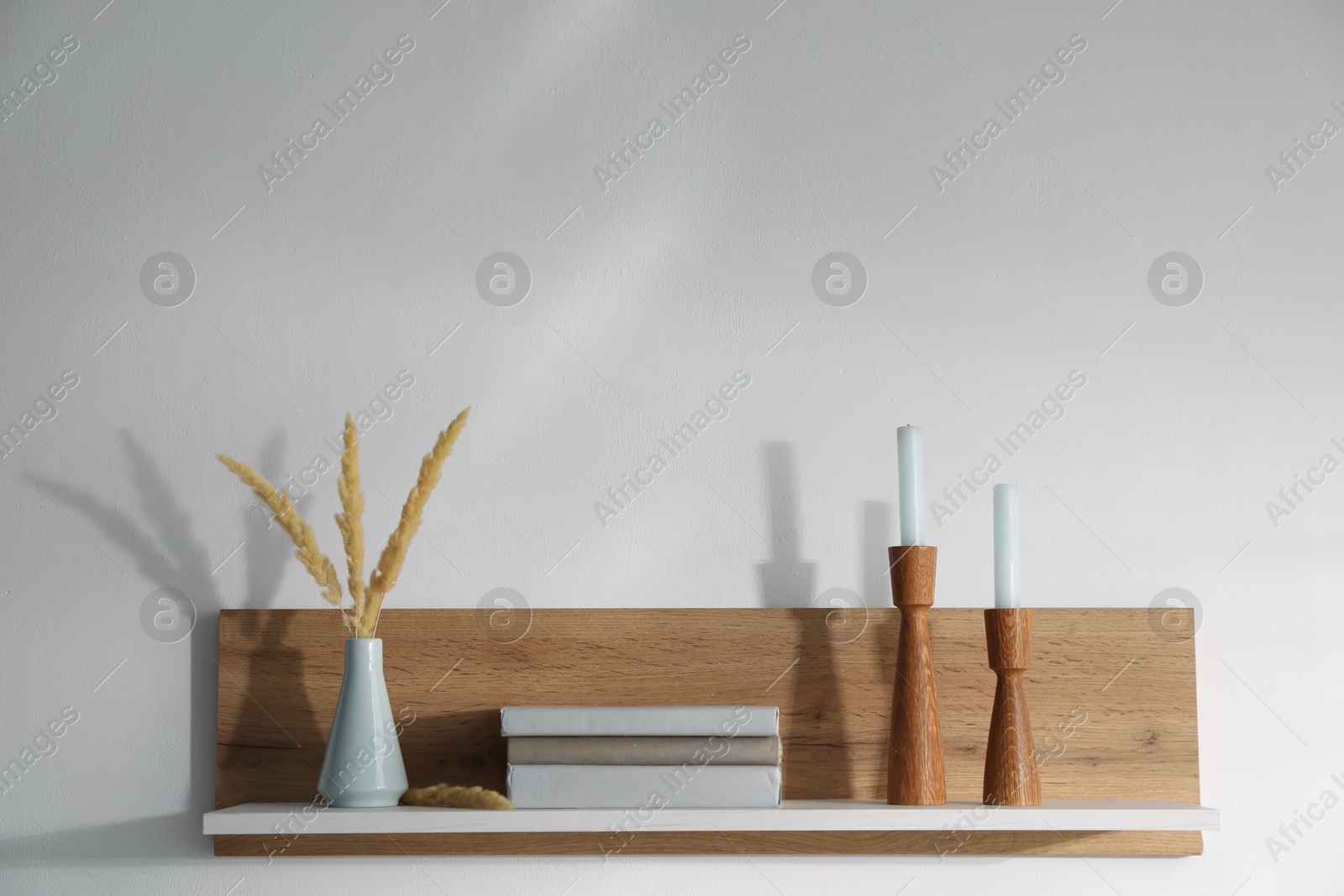 Wooden shelf with books and decor on white background. Space for text Photo of Wooden shelf with books and decor on white background. Space for text