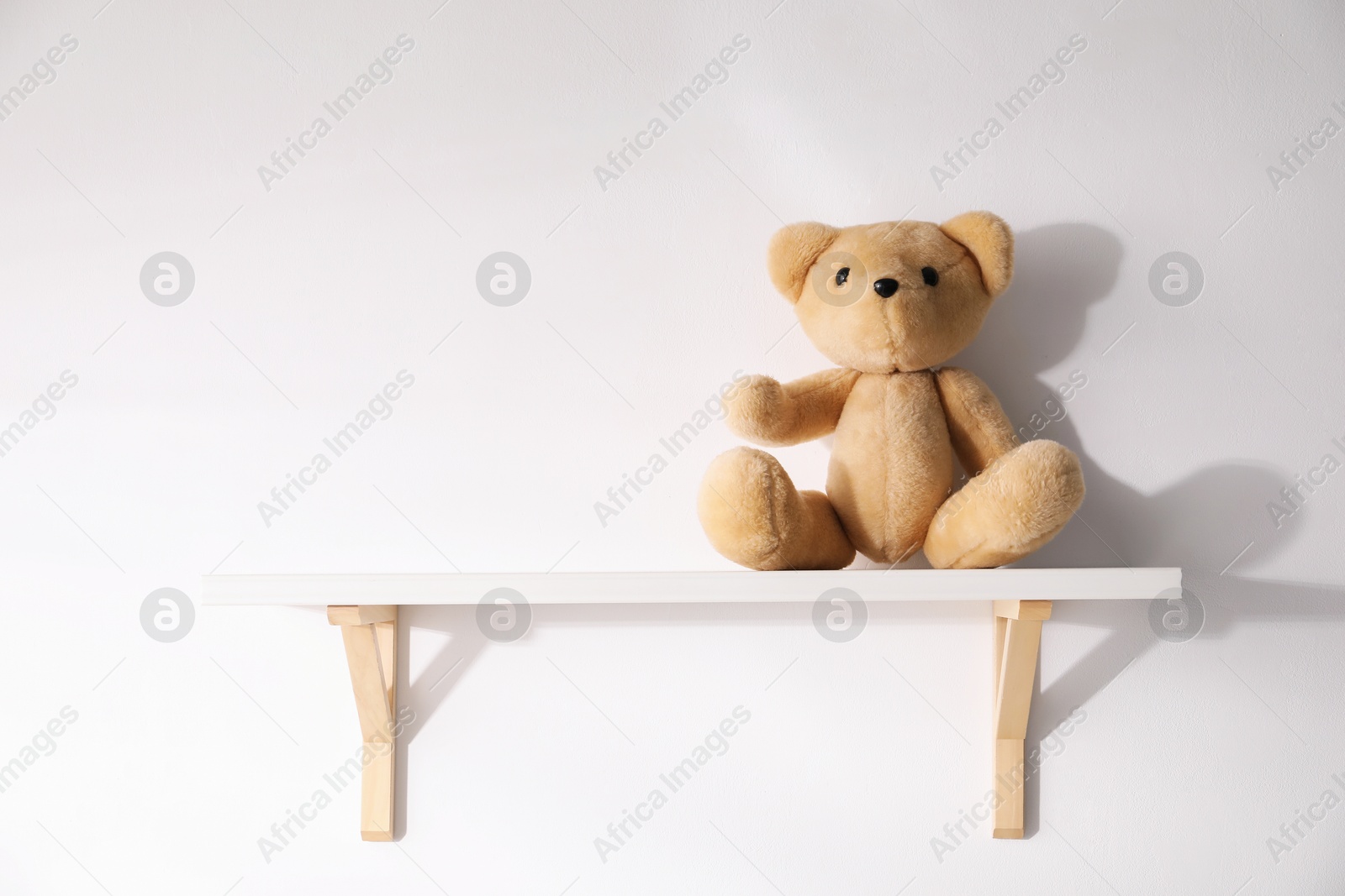 Shelf with teddy bear on white background. Space for text Photo of Shelf with teddy bear on white background. Space for text