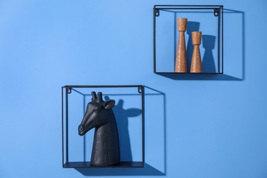 Photo of Metal shelves with stylish decor on blue background