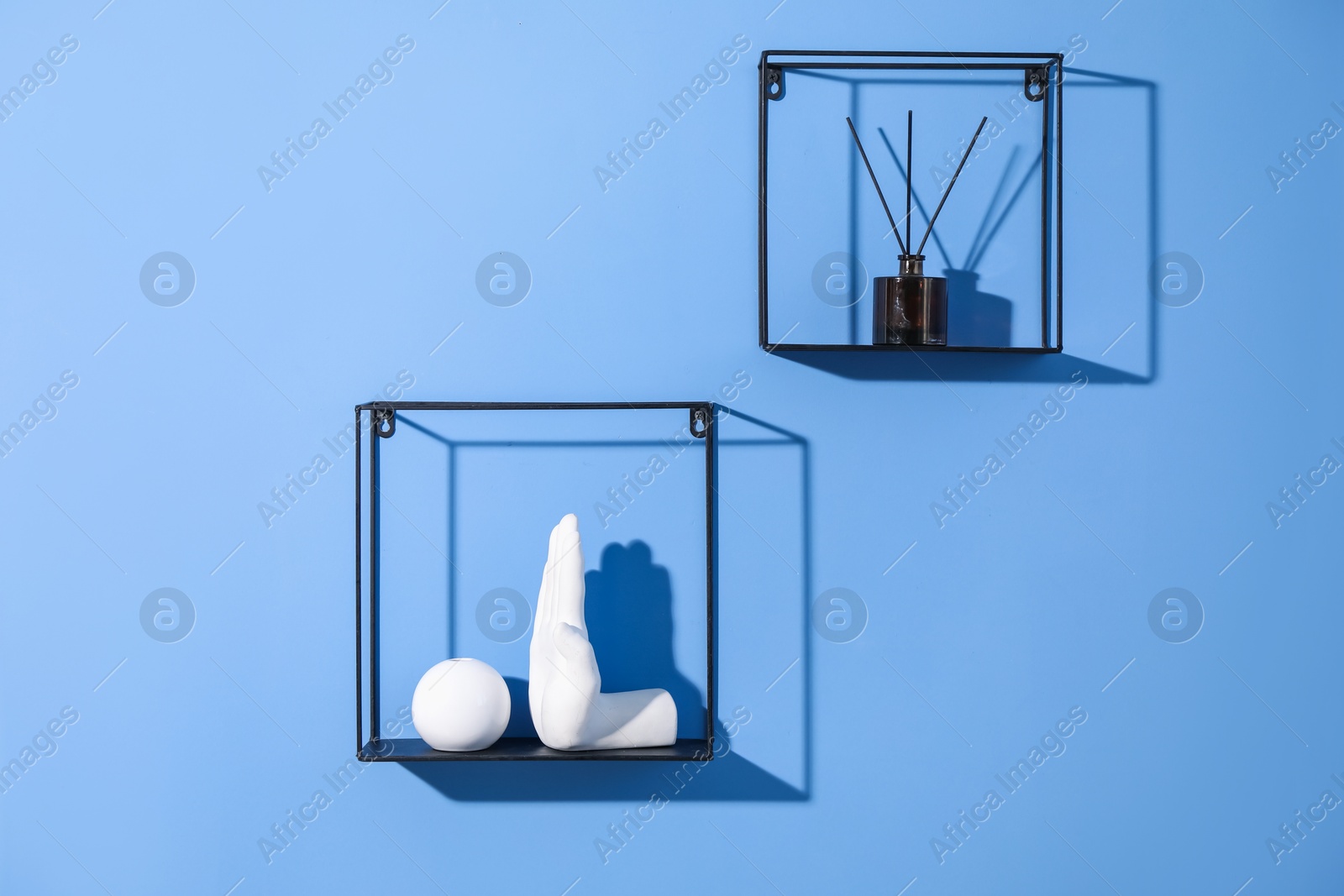 Metal shelves with stylish decor on blue background Photo of Metal shelves with stylish decor on blue background