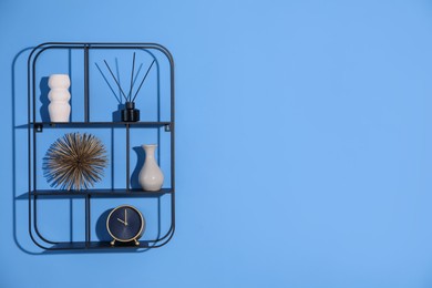 Photo of Metal shelves with stylish decor on blue background. Space for text