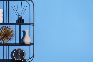 Photo of Metal shelves with stylish decor on blue background. Space for text
