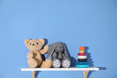 Photo of Shelf with different toys on blue background. Space for text