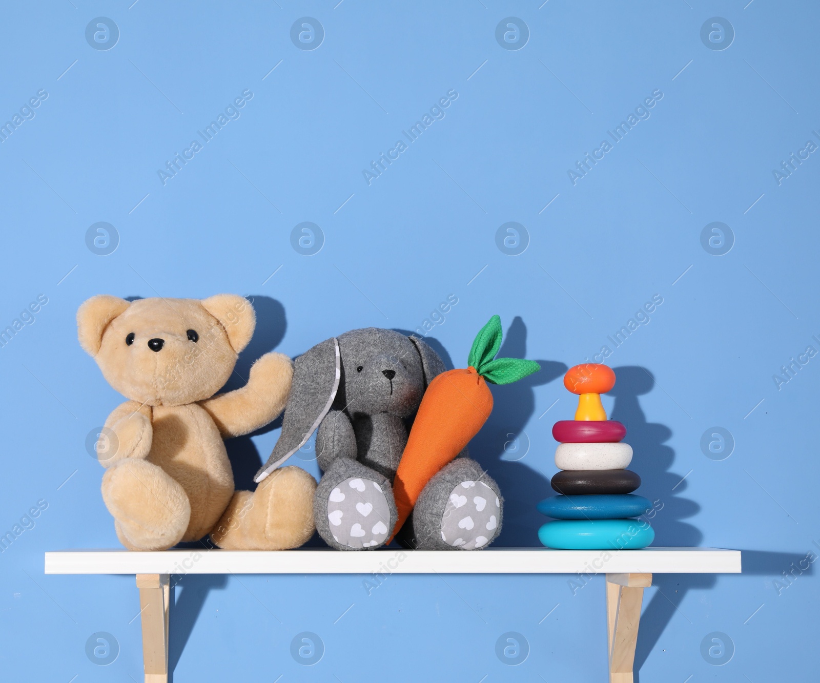 Shelf with different toys on blue background Photo of Shelf with different toys on blue background