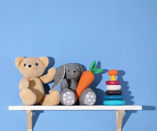 Photo of Shelf with different toys on blue background