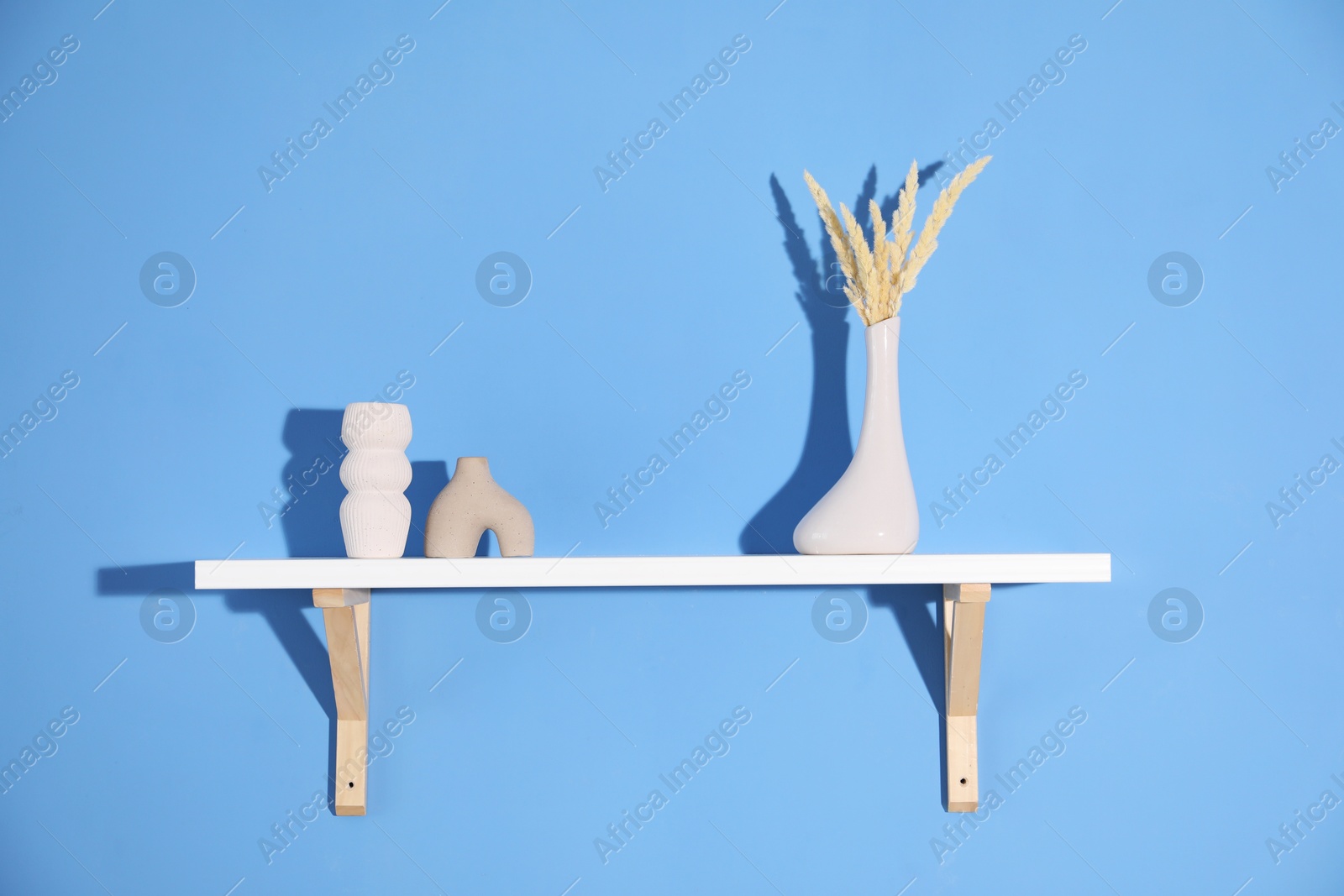 Photo of Shelf with beautiful decor on blue background
