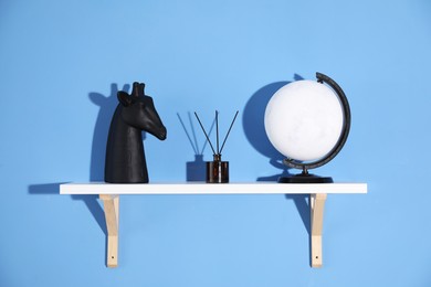 Photo of Shelf with stylish decor on blue background