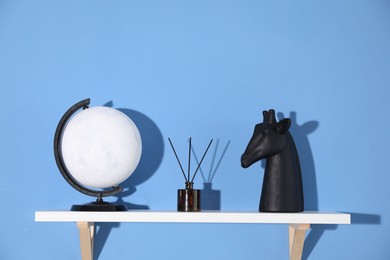 Photo of Shelf with stylish decor on blue background