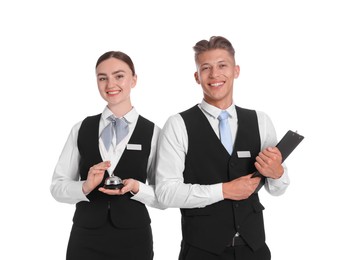Photo of Smiling receptionists in uniforms with service bell and clipboard on white background