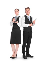 Photo of Smiling receptionists in uniforms with service bell and clipboard on white background