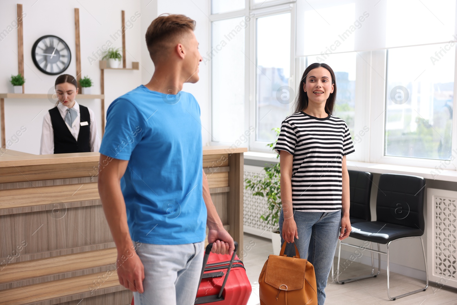 Couple of tourists and receptionist in hotel Photo of Couple of tourists and receptionist in hotel