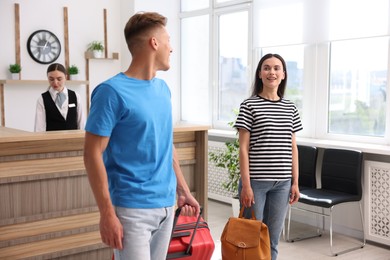 Photo of Couple of tourists and receptionist in hotel