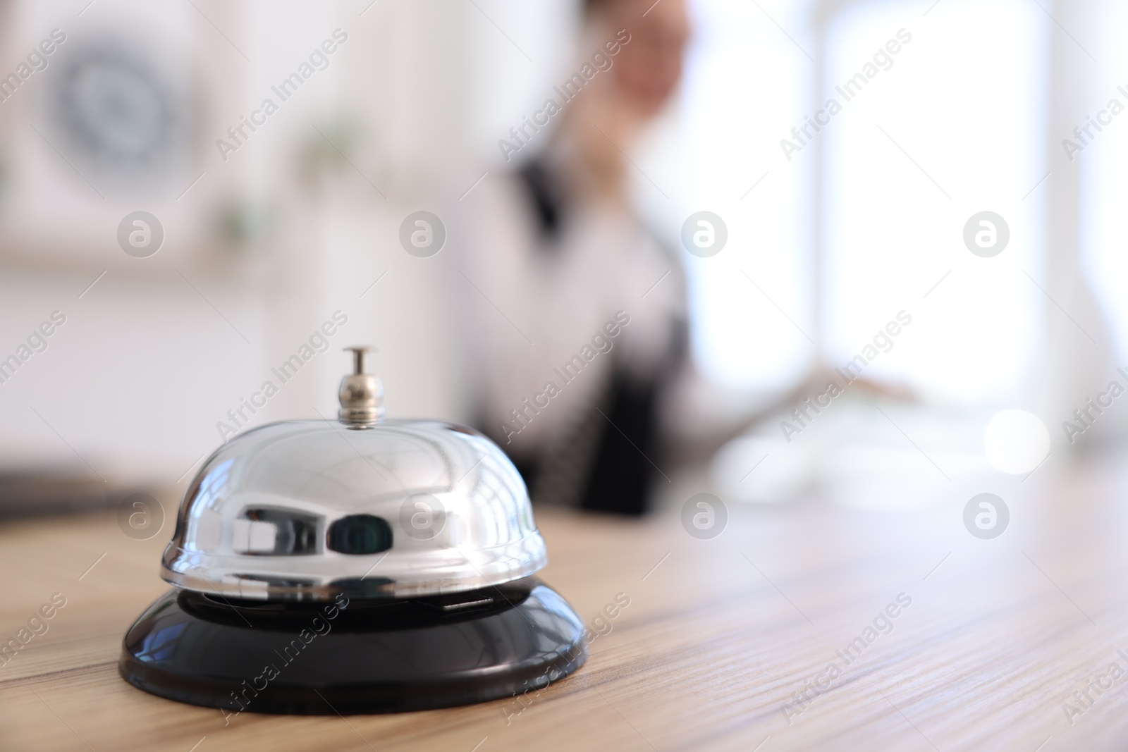Photo of Receptionist working in hotel, focus on service bell