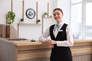 Photo of Portrait of smiling receptionist at workplace in hotel
