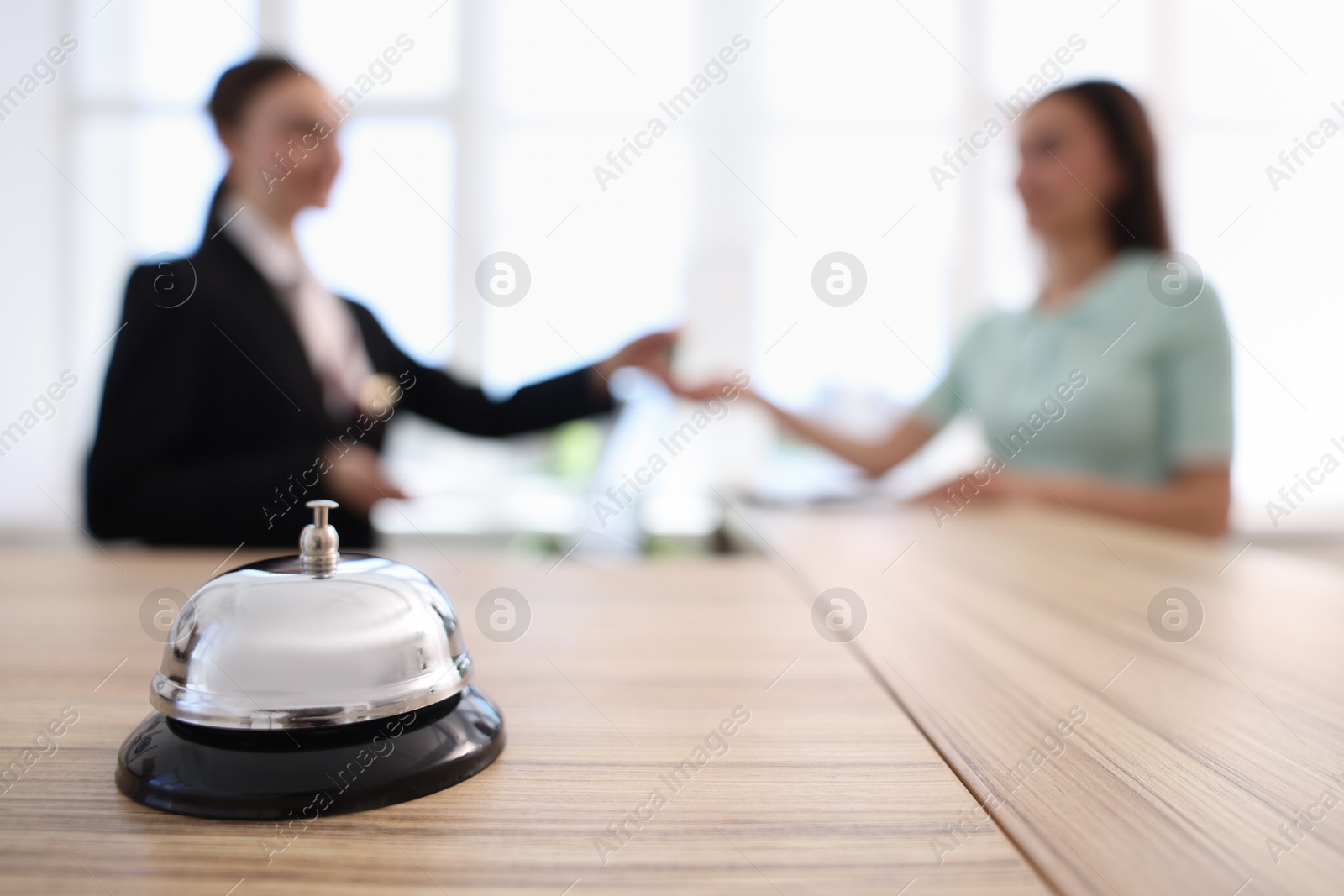 Receptionist working with client in hotel, focus on service bell Photo of Receptionist working with client in hotel, focus on service bell