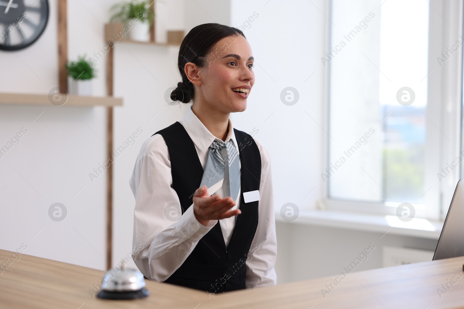 Smiling receptionist working at reception desk in hotel Photo of Smiling receptionist working at reception desk in hotel