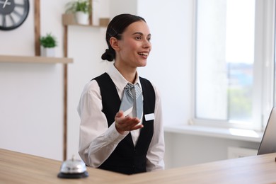 Photo of Smiling receptionist working at reception desk in hotel