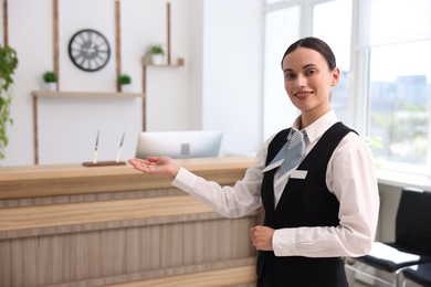 Photo of Portrait of smiling receptionist welcoming in hotel